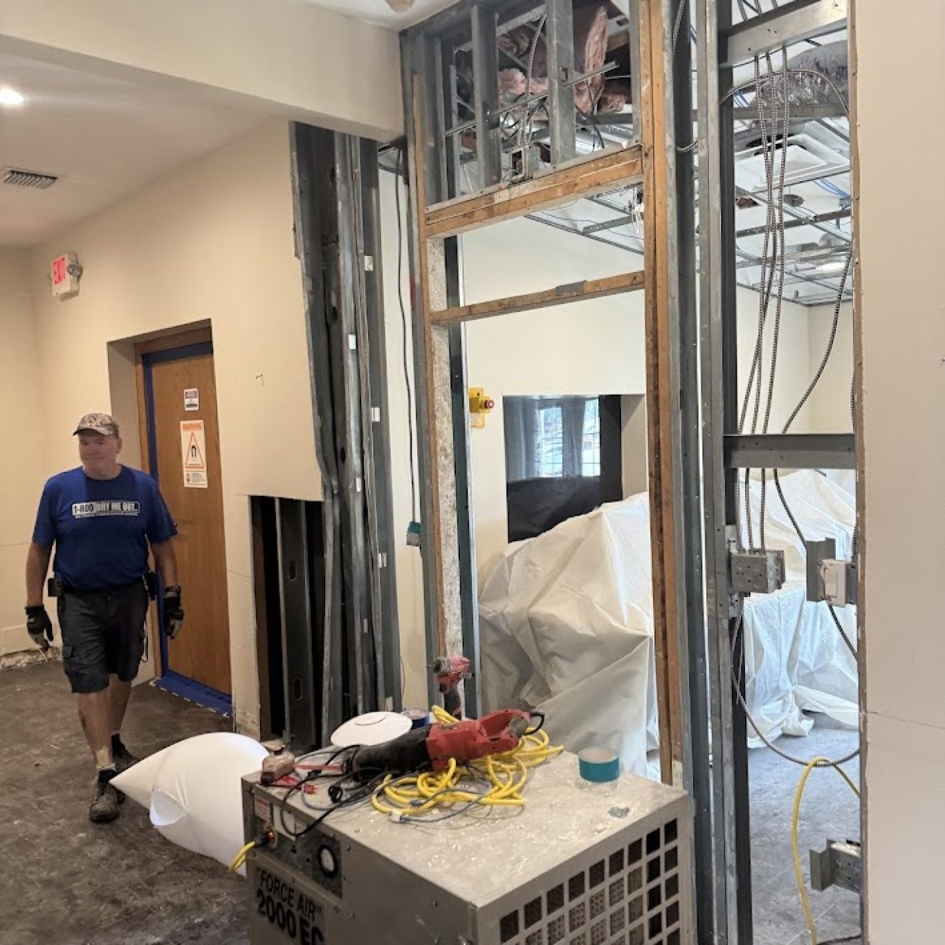 Restoration technician setting up drying equipment after water damage in a Wesley Chapel home